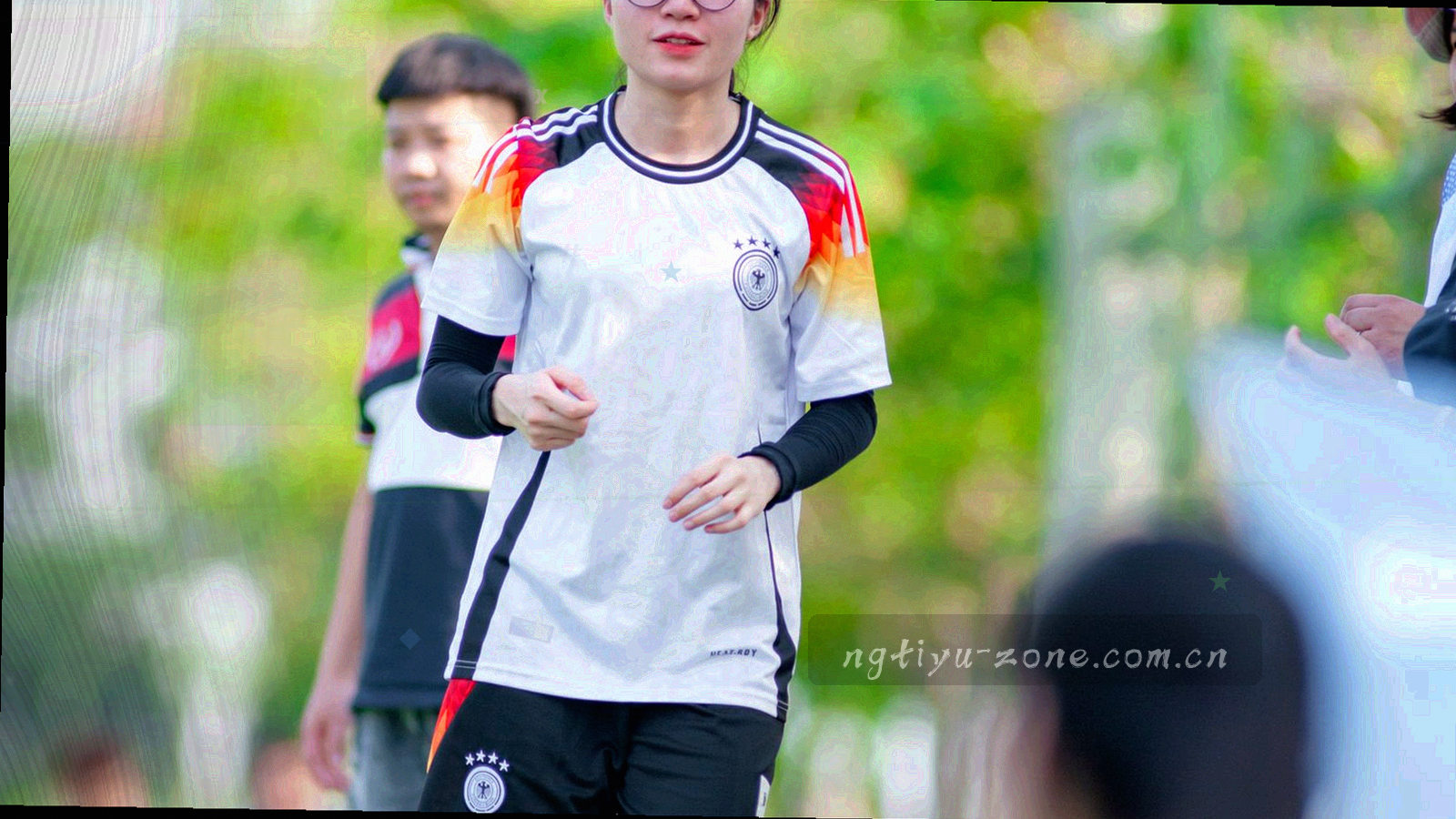 俯瞰夜间球场灯光与看台轮廓，画面偏暗，点缀青绿光斑